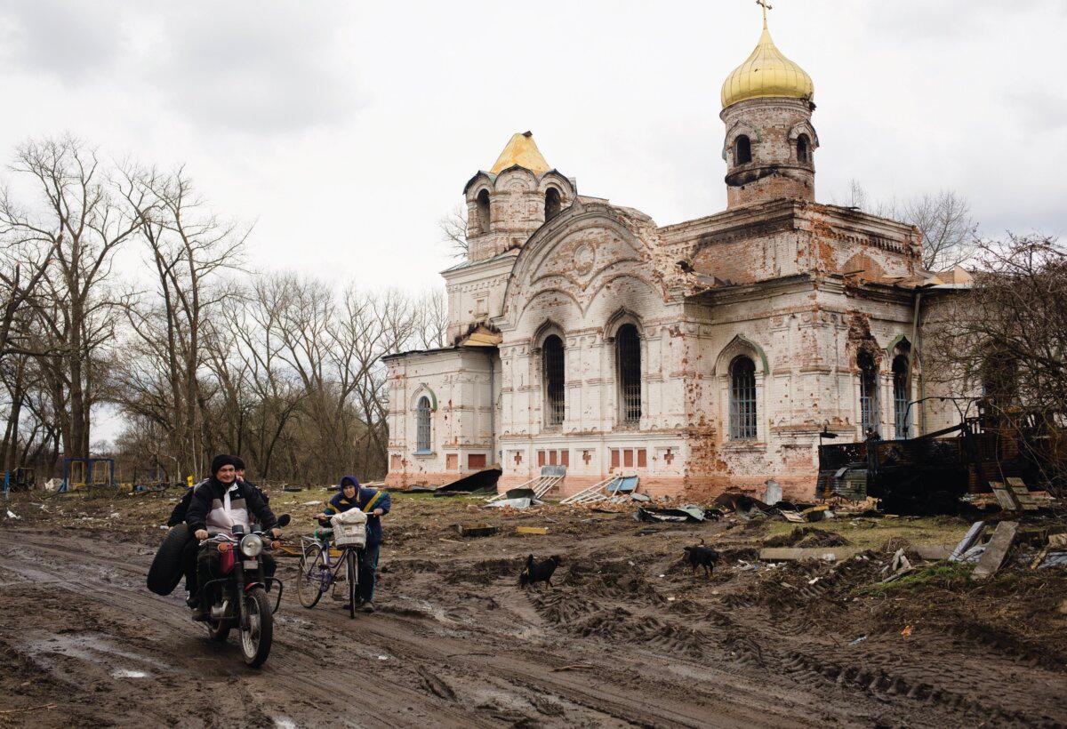 Local residents pass by a destroyed church that served as a military base for Russian soldiers on April 10, 2022, in the village of Lukashivka, Ukraine. (Anastasia Vlasova/Stringer/Getty Images News)