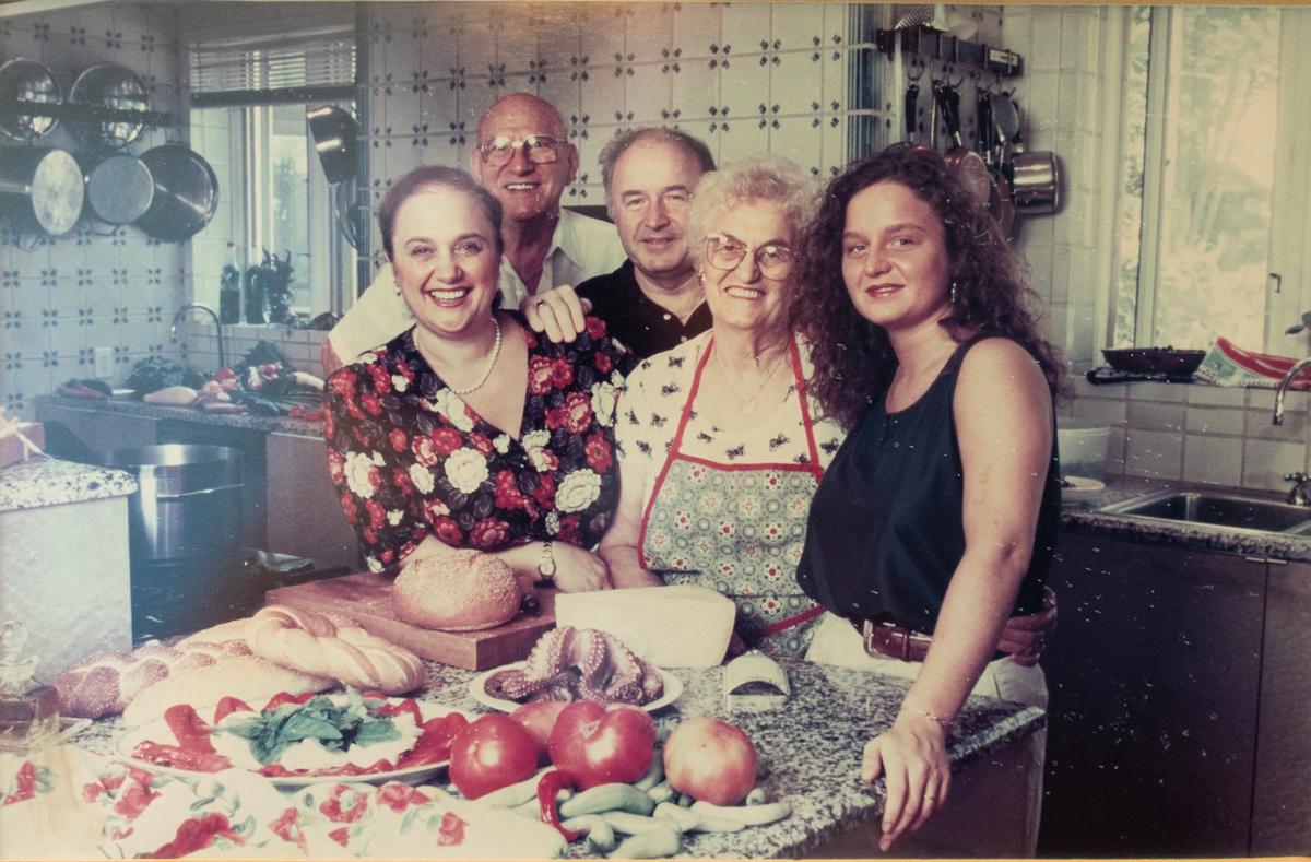 (L–R) Ms. Bastianich; her mother’s companion, Giovanni Bencina; her former husband, Felice  Bastianich; her mother, Erminia Motika; and her daughter, Tanya Bastianich Manuali gather in her home kitchen in this old photo. (Courtesy of Lidia Bastianich)
