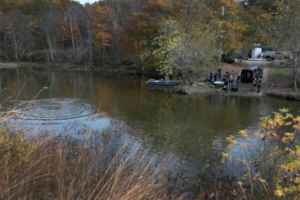  Law enforcement officers use an underwater robotic camera to search the water around the Pejepscot Boat Ramp on the Androscoggin River, where the suspect being searched for in connection with two mass shootings abandoned his vehicle in Lisbon, Maine, on Oct. 27, 2023. (Joe Raedle/Getty Images)