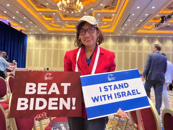 Dolly DeLeon, a Trump supporter from Las Vegas, poses with signs at the Republican Jewish Coalition’s annual leadership summit at the Venetian Hotel’s convention center in Las Vegas on Oct. 28, 2023. (Janice Hisle/The Epoch Times)