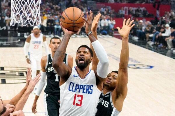 Los Angeles Clippers forward Paul George (C) shoots as San Antonio Spurs forward Keldon Johnson (R) defends during the first half of an NBA basketball game in Los Angeles on Oct. 29, 2023. (Mark J. Terrill/AP Photo)