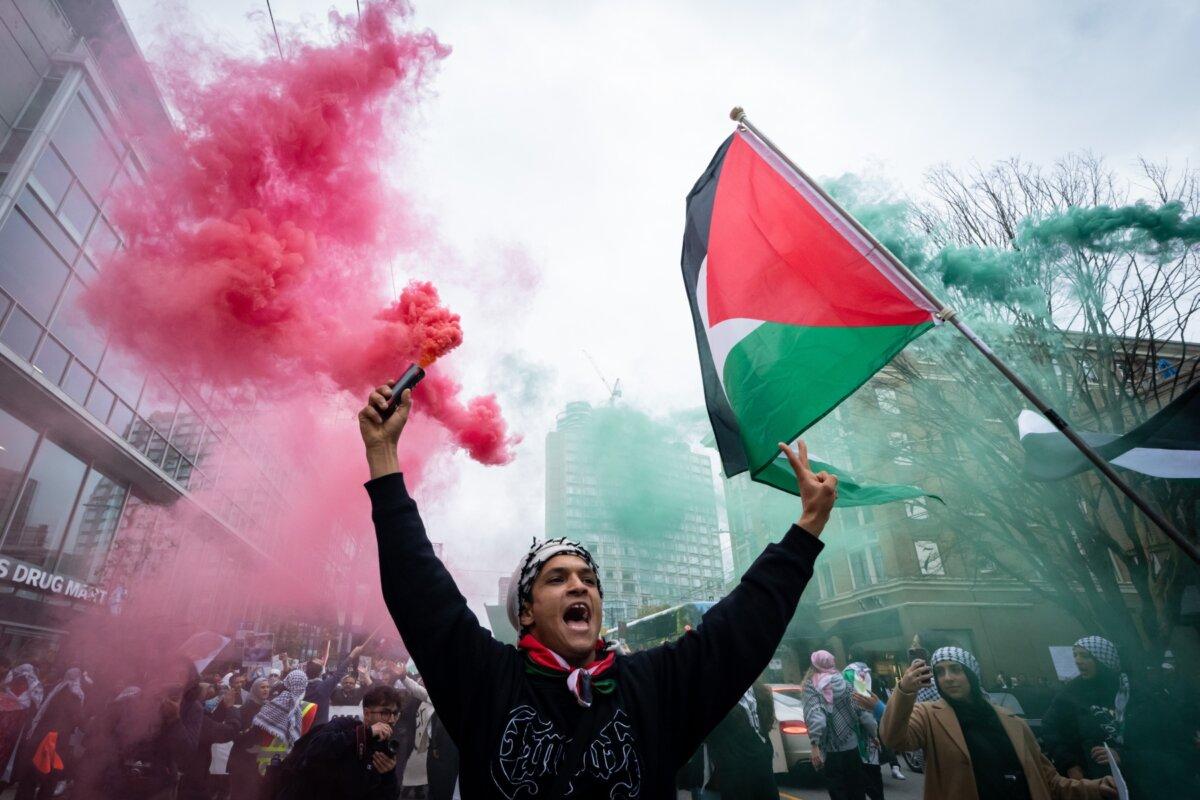 A demonstrator cheers and chants as smoke bombs go off during a protest in support of Palestine, in Vancouver, B.C., on Oct. 21, 2023. (Ethan Cairns/The Canadian Press)