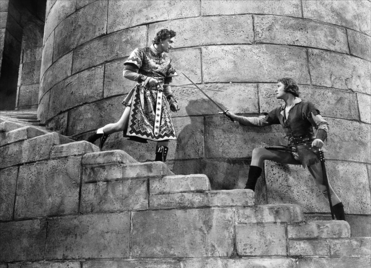Robin Hood (played by Errol Flynn) faces off against Sir Guy of Gisbourne (Basil Rathbone). (MovieStillsDB)