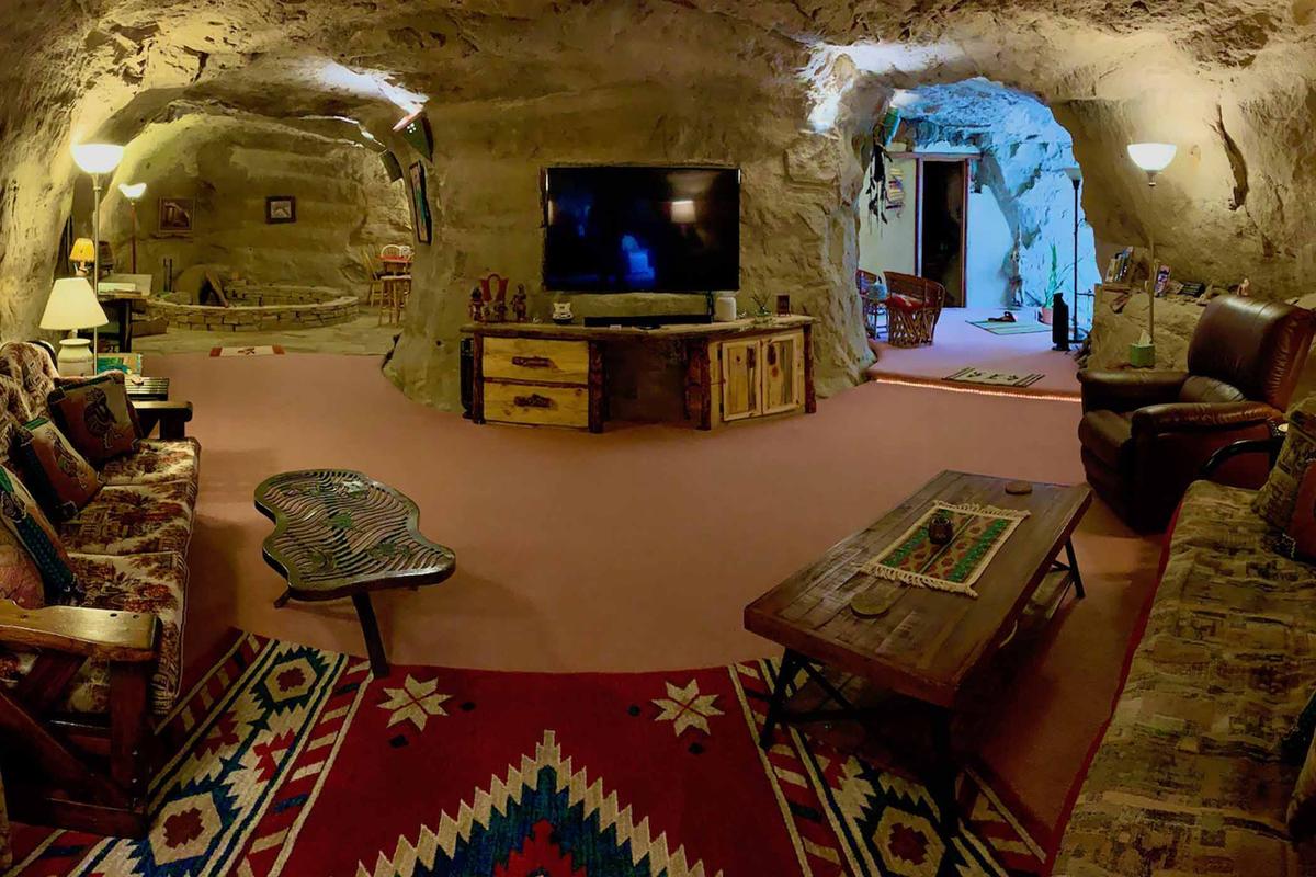 An interior view of Koko’s Cave shows the living room, hearth, and front entryway. (Courtesy of <a href="https://kokoscave.us/">Kokopelli’s Cave</a>)