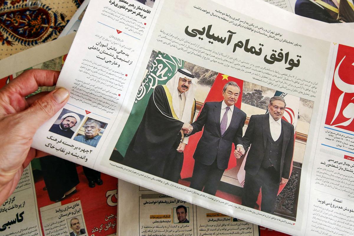 A man in Tehran holds a local newspaper with a front page report on the China-brokered deal between Iran and Saudi Arabia to restore ties, signed in Beijing the previous day, on March, 11 2023. (ATTA KENARE/AFP via Getty Images)