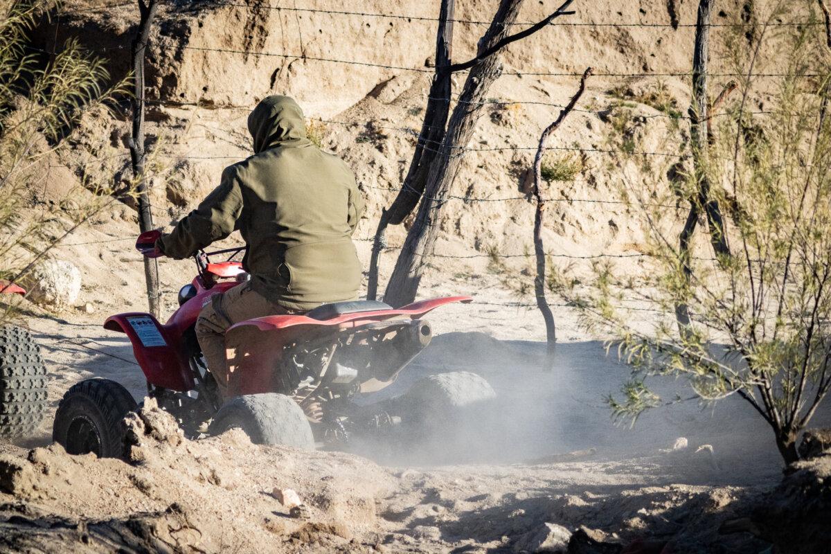 Human smugglers drive ATVs on the Mexican side of the United States border wall near Jacumba, Calif., on Oct. 31, 2023. (John Fredricks/The Epoch Times)