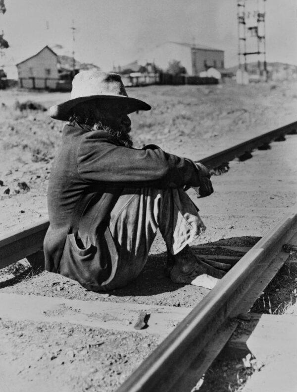 An Australian Aborigine sits beside railway lines in Kalgoorlie, Western Australia, on June 16, 1964. (Daily Express/Pictorial Parade/Archive Photos/Getty Images)