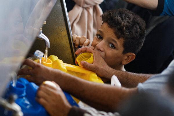 A child looks on as Palestinians gather to collect water, amid water shortages, in Khan Younis, Gaza Strip, on Nov. 2, 2023. (Mohammed Salem/Reuters)