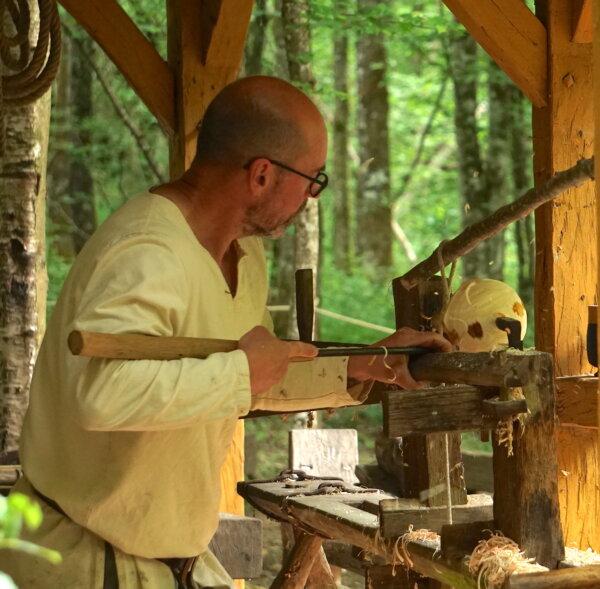  A bowl turner carves out wood for bowls on a handmade pole lathe. (Copyright Guédelon)