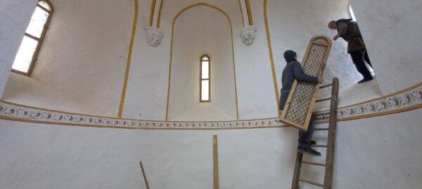 A model of a window for Guédelon’s chapel, made by a carpenter, is carried to its setting. (Copyright Guédelon)