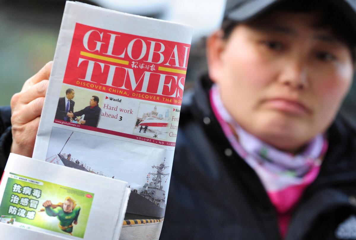 A news vendor places a copy of the Global Times, published by the People's Daily, the mouthpiece of the ruling Communist Party, for display on her newsstand in Beijing on April 20, 2009. (Frederic J. Brown/AFP via Getty Images)
