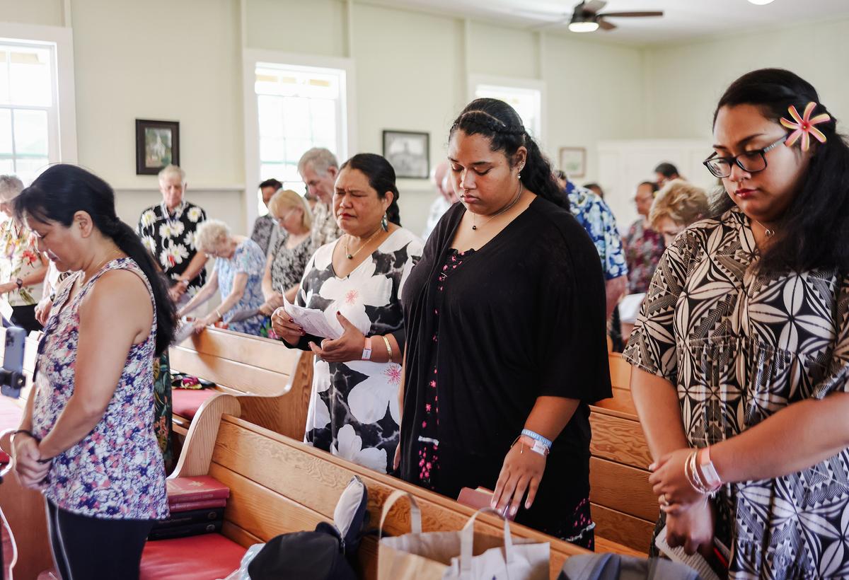 Members of Lahaina United Methodist Church pray during Sunday services at their temporary location at near Lahaina, Hawaii, on Oct. 8, 2023 (Mario Tama/Getty Images)