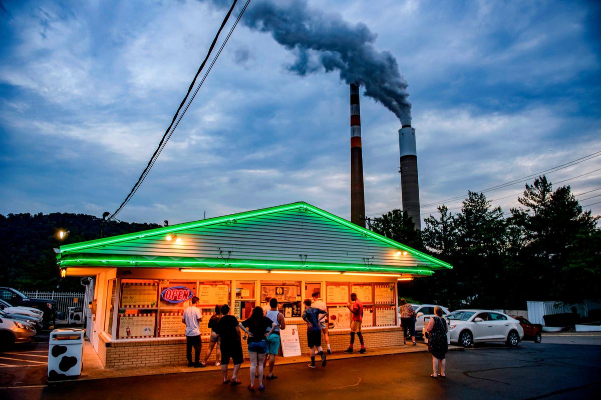  People line up for ice cream at Glens Custard in the shadow of the GenOns Cheswick Power Station, which still burns coal to produce 637 megawatts of electricity for the region, in Cheswick, Pa., on June 7, 2021. (Jeff Swensen/Getty Images)