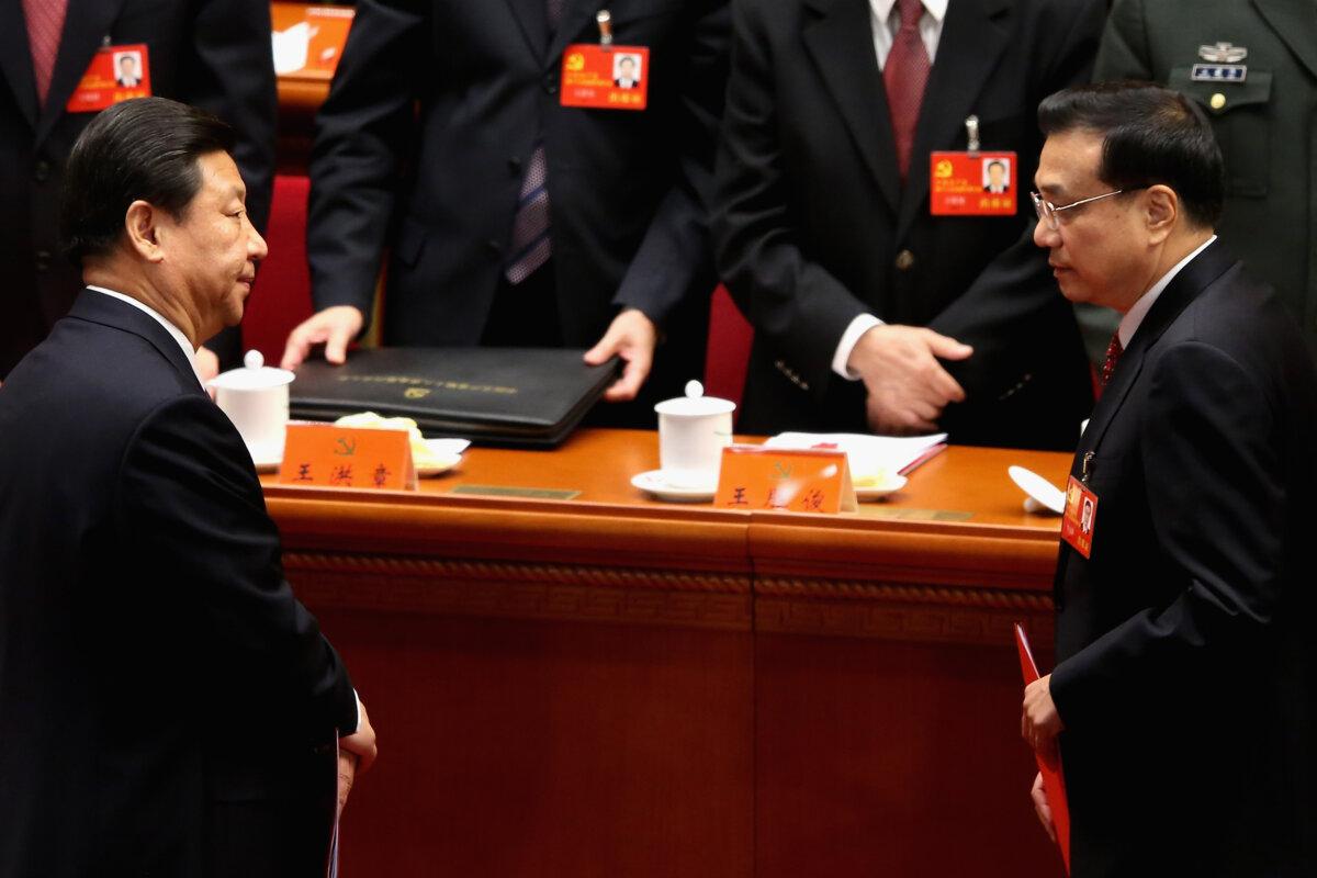 China's deputy leader Xi Jinping (L) and China's Vice-Premier Li Keqiang (R) leave their seats after the closing session of the 18th National Congress of the Communist Party of China (CPC) at the Great Hall of the People in Beijing on Nov. 14, 2012. (Feng Li/Getty Images)