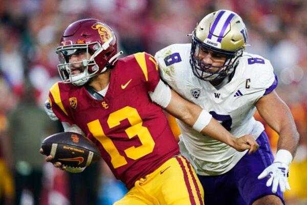 Southern California quarterback Caleb Williams, left, gets away from Washington defensive end Bralen Trice during the first half of an NCAA college football game in Los Angeles on Nov. 4, 2023. (Ryan Sun/AP Photo)