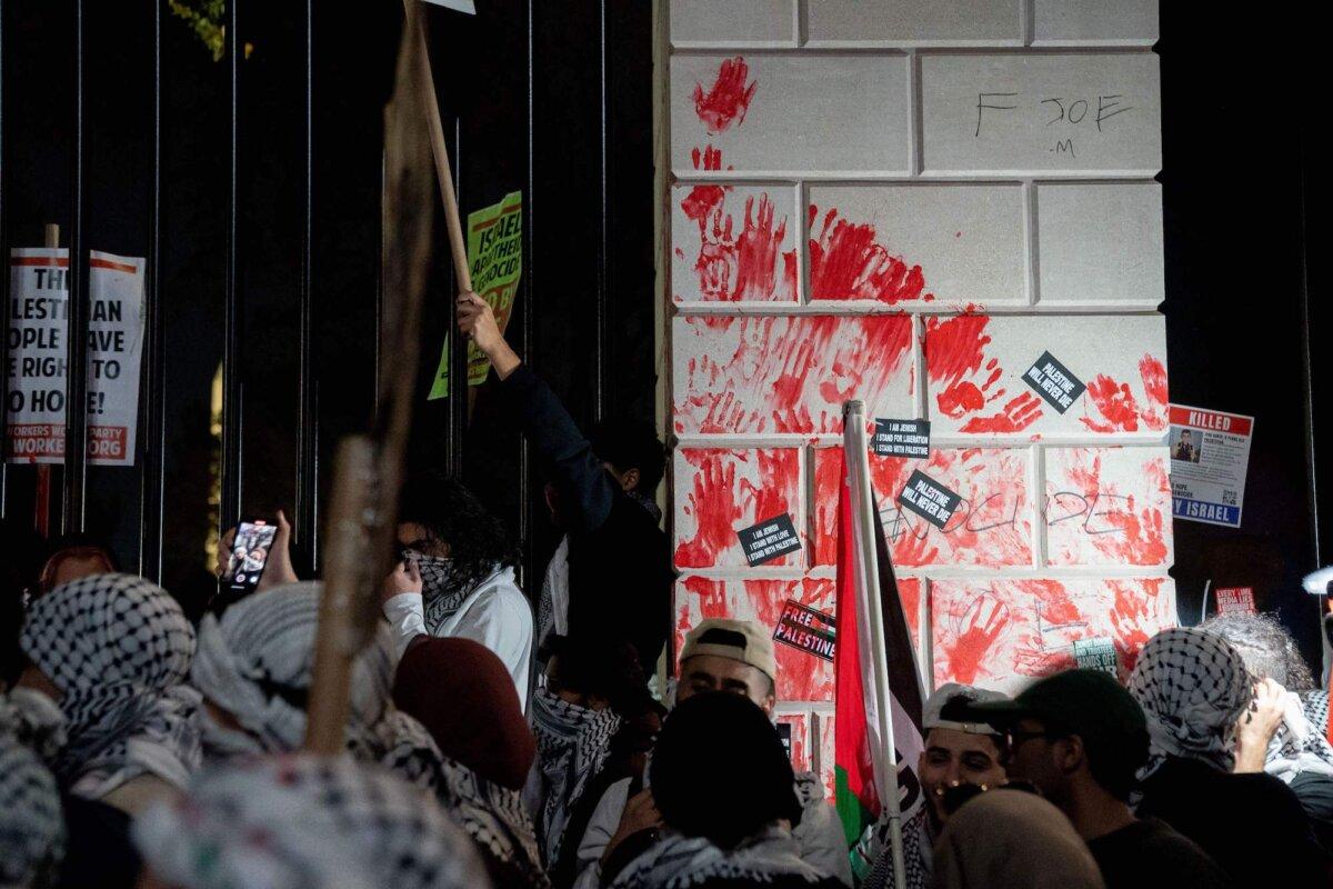 Demonstrators leave red hand prints on the fence in front of the White House during a pro-Palestinian rally in Washington, D.C., on Nov. 4, 2023. (Stefani Reynolds/AFP via Getty Images)