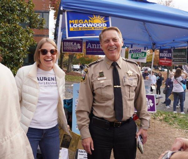 Loudoun County Sheriff Republican Mike Chapman (right) campaigns for re-election outside the Loudoun County Office of Elections in Leesburg, Va., on Nov. 4, 2023, the last day of in-person early voting. Lauren Shernoff, a Loudoun County School Board candidate for the Leesburg District, is also there to speak to voters. (Terri Wu/The Epoch Times)