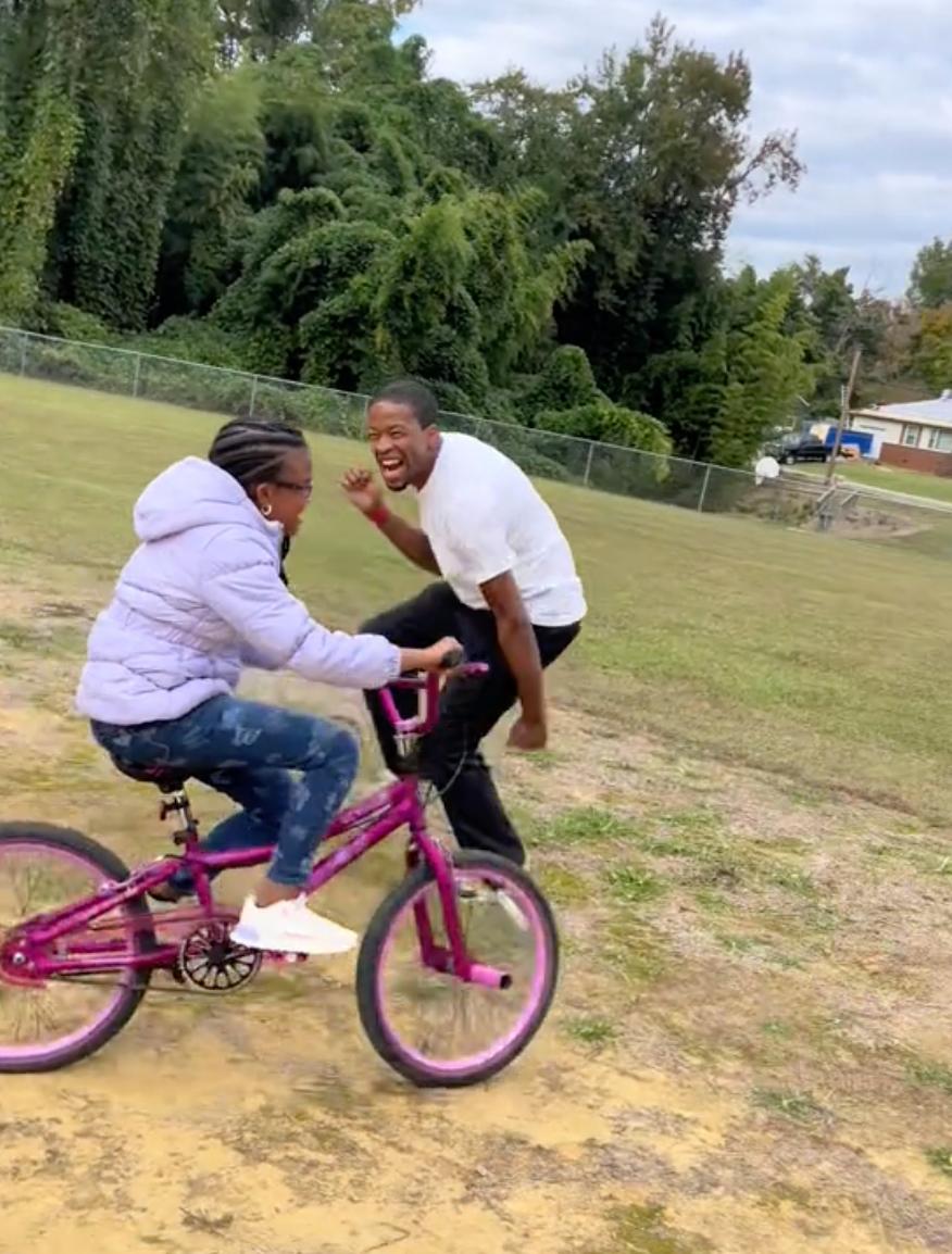 Mr. Gilchrist jumps for joy on seeing his daughter, Armiah, riding a bike for the first time. (Courtesy of Mariah Gilchrist)