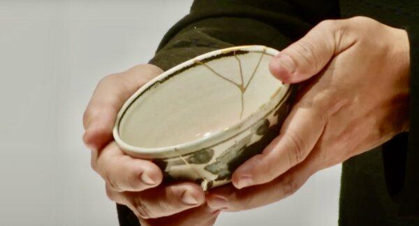 Japanese contemporary artist Makoto Fujimura shows a bowl with golden lacquer repair to the audience at the Alliance for Responsible Citizenship conference in London, England, on Nov. 2, 2023. (Screenshot by The Epoch Times/ Alliance for Responsible Citizenship)