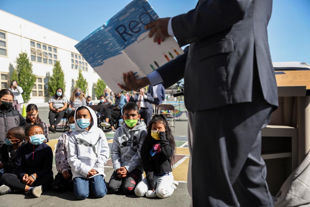 California State Superintendent of Schools Tony Thurmond reads from the book ""Red: A Crayon's Story,"" about a mislabeled crayon that has an identity crisis, to second grade students at Nystrom Elementary School in Richmond, Calif., on May 17, 2022. (Justin Sullivan/Getty Images)