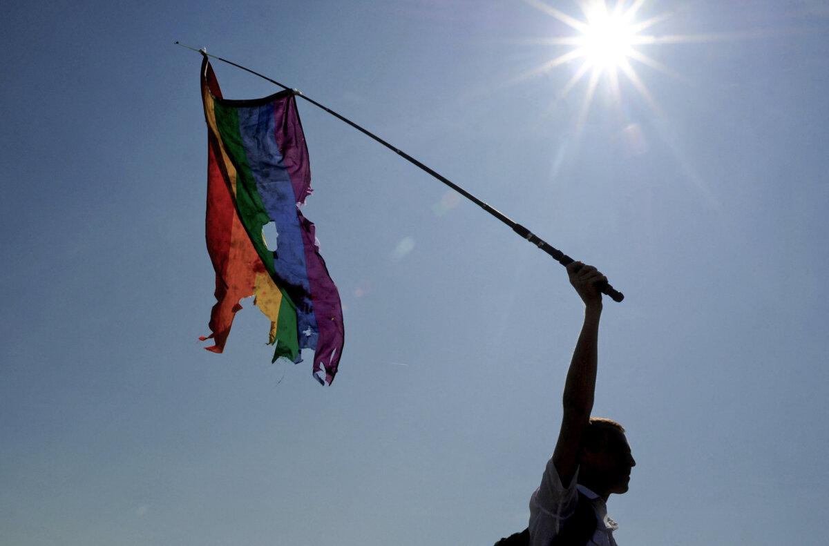 An activist waves a damaged rainbow flag during gay pride in St. Petersburg on July 26, 2014. (Olga Maltseva/AFP via Getty Images)