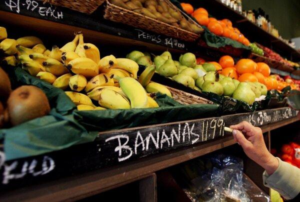 A fruit and vegetable shop storekeeper changes the price of bananas in Sydney, Australia, on July 14, 2006. (Ian Waldie/Getty Images)