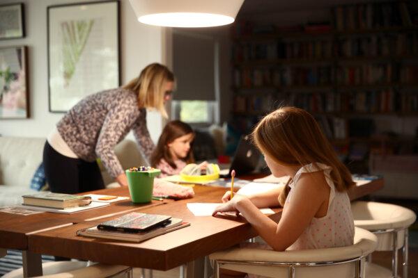 Children do schoolwork at home with their mother in San Anselmo, Calif., on March 18, 2020. (Ezra Shaw/Getty Images)