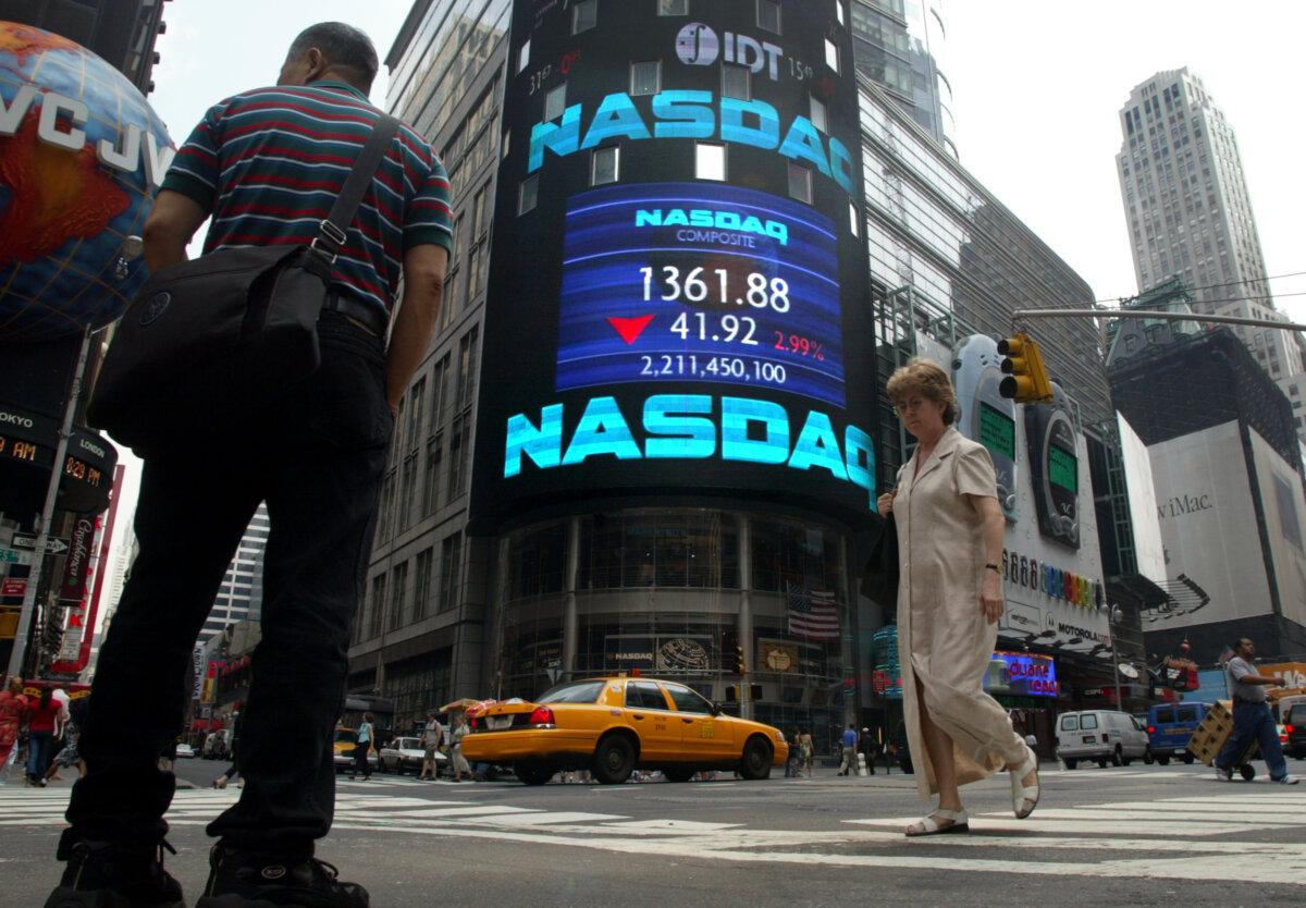 Pedestrians walk past NASDAQ headquarters July 2, 2002 in New York City. The NASDAQ composite index closed at another five-year low, down 45.95 or 3.3 percent to close at 1,357.85, after falling 4.1 percent. (Mario Tama/Gettty Images)