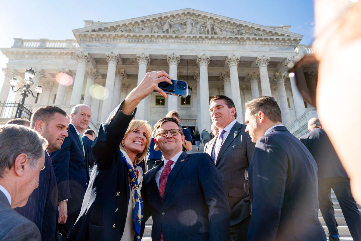 The new speaker of the House, Rep. Mike Johnson (R-La.), takes a selfie with Rep. Claudia Tenney (R-N.Y.) after a news conference at the U.S. Capitol in Washington on Oct. 25, 2023. (AP Photo/Jose Luis Magana)