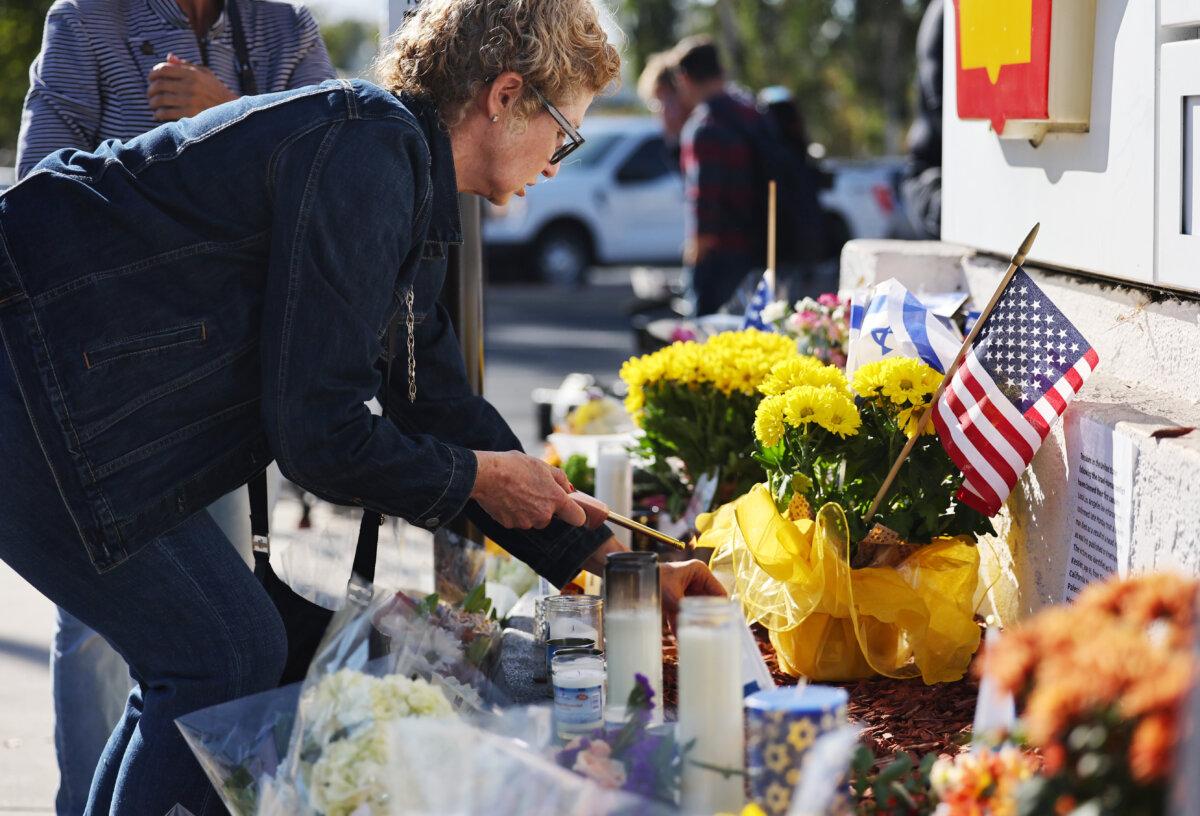 A person lights a candle at a makeshift memorial at the site of an altercation between 69-year-old Paul Kessler, who was Jewish, and pro-Palestinian protestor in Thousand Oaks, Calif., on Nov. 7, 2023. (Mario Tama/Getty Images)
