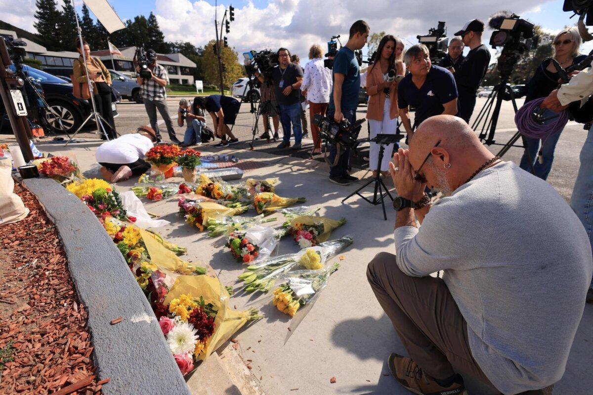 A man prays as flowers and candles are placed at the intersection where a protest on Nov. 5 led to the death of a Jewish man after an altercation with a pro-Palestinian man at a demonstration in Thousand Oaks, Calif., on Nov. 7, 2023. (David Swanson/AFP via Getty Images)