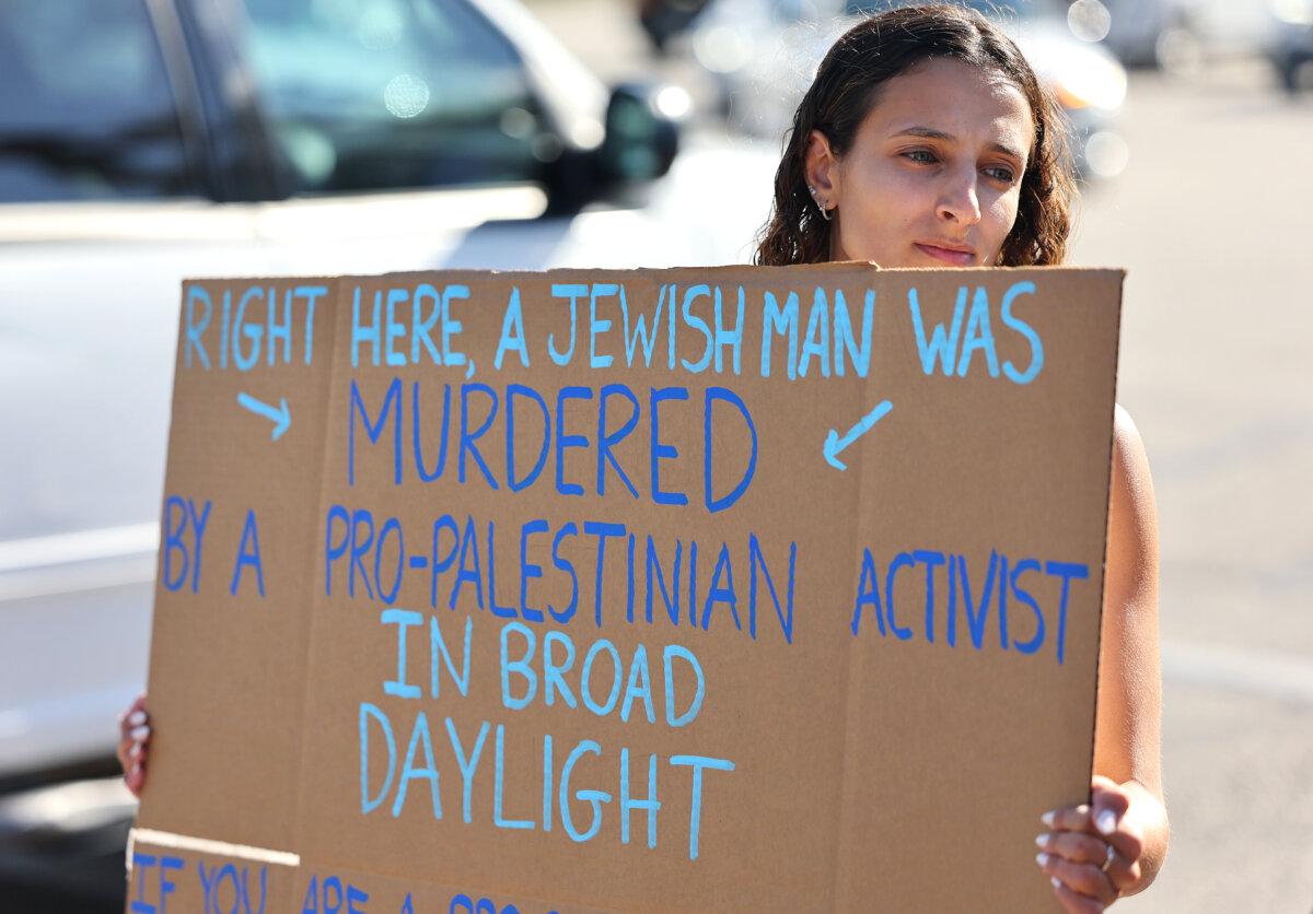A demonstrator holds a sign at a makeshift memorial at the site of an altercation between 69-year-old Paul Kessler, who was Jewish, and a pro-Palestinian protestor in Thousand Oaks, Calif., on Nov. 7, 2023. (Mario Tama/Getty Images)