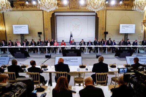 French President Emmanuel Macron (C) speaks next to representatives from states, international organisations, businesses, development banks, and NGOs during an international humanitarian conference for civilians in Gaza, at the Elysée Presidential Palace, in Paris on Nov. 9, 2023. (Ludovic Marin/Pool/AFP via Getty Images)
