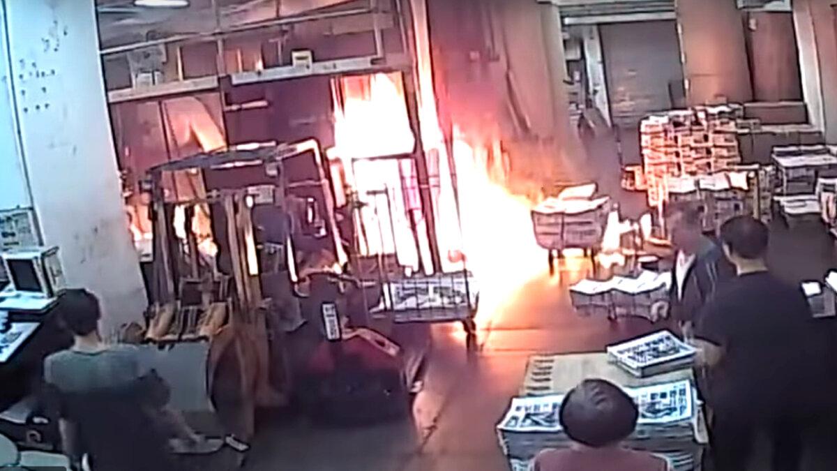 Staff at the print shop that prints the Hong Kong edition of The Epoch Times react to a fire started by four masked men in Hong Kong on Nov. 19, 2019.