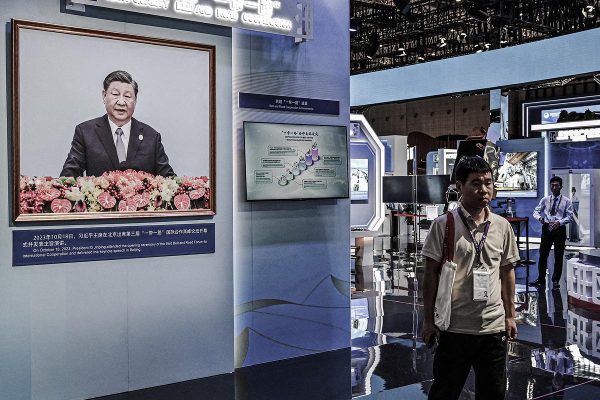 A portrait of China's President Xi Jinping is seen as people visit the China stand during the 6th China International Import Expo (CIIE) in Shanghai on Nov. 5, 2023. (Photo by Hector RETAMAL / AFP) (Photo by HECTOR RETAMAL/AFP via Getty Images)