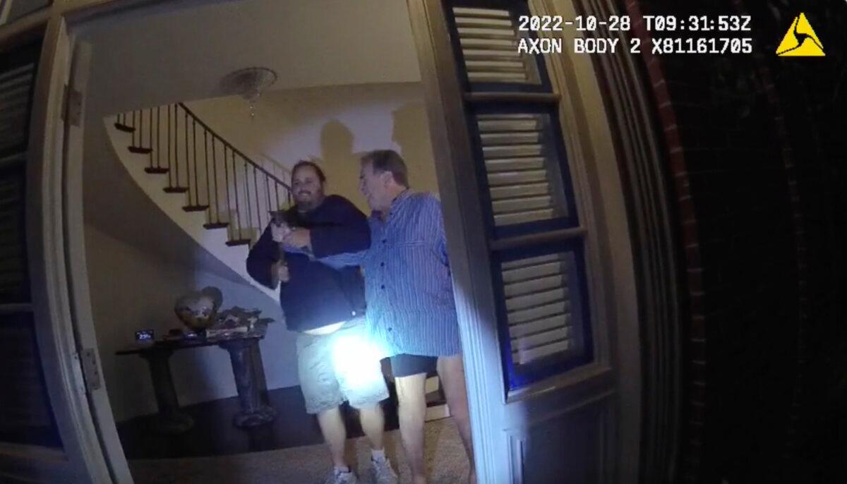The husband of former U.S. House Speaker Nancy Pelosi, Paul Pelosi (R), fights for control of a hammer with his assailant David DePape during a brutal attack in the couple's San Francisco home on Oct. 28, 2022, in a still from police body-camera video. (San Francisco Police Department via AP)