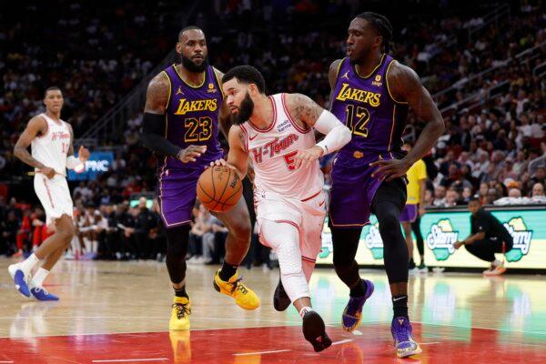 Fred VanVleet (5) of the Houston Rockets drive through defenders Taurean Prince (12) of the Los Angeles Lakers and LeBron James (23) during the second half in Houston at Toyota Center on Nov. 8, 2023. (Carmen Mandato/Getty Images)
