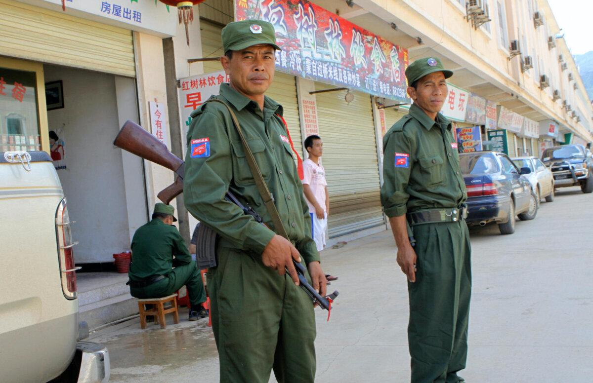 Ethnic Kokang soldiers of a newly formed Kokang ethnic armed group stand outside a deserted market as a convoy carrying diplomats, and journalists visit the Burma-China border town of Laukkai, the capital of Kokang, on Sept. 8, 2009. (Khin Maung Win/AFP via Getty Images)