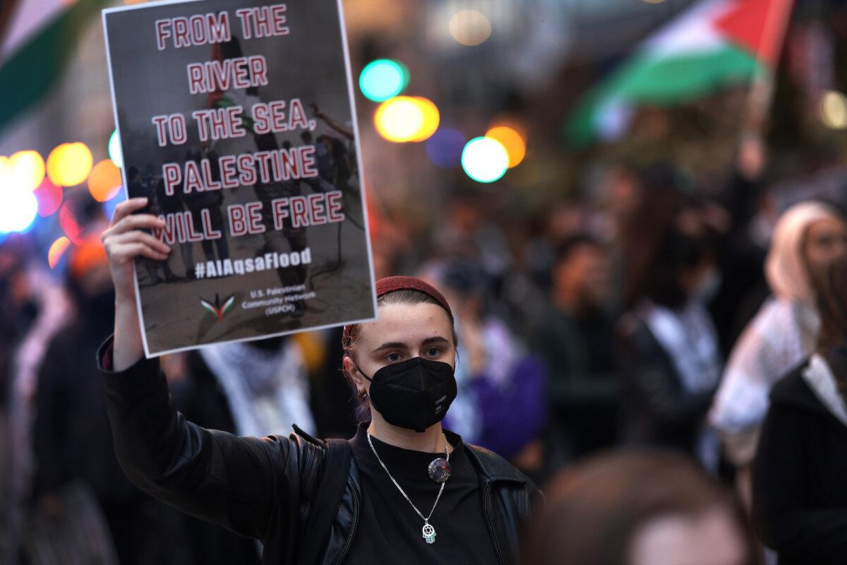 A demonstrator holds a sign reading '"From the river to the sea, Palestine will be free" at a pro-Palestinian rally in Chicago, Ill., on Oct. 11, 2023. (Scott Olson/Getty Images)