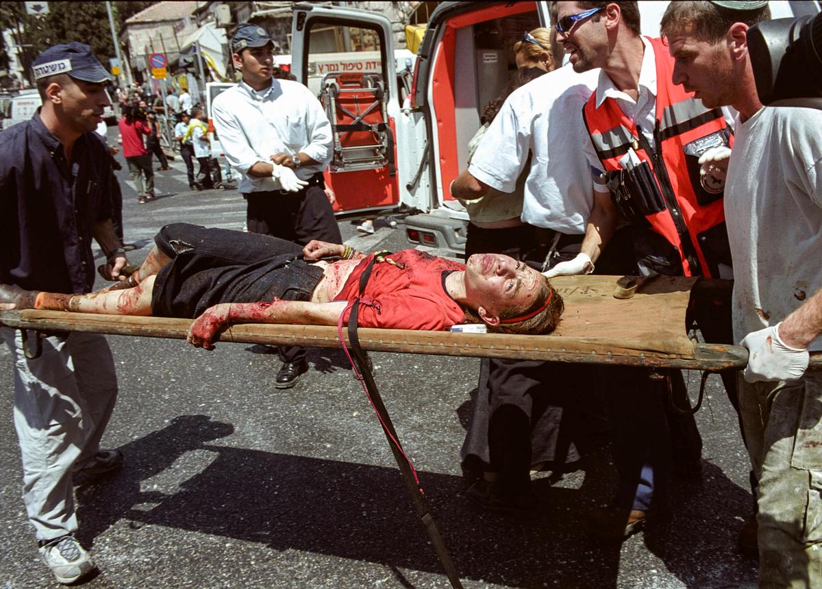  Israeli medics evacuate an injured woman from the site of a Palestinian suicide bombing in Jerusalem on Aug. 9, 2001. (Getty Images)