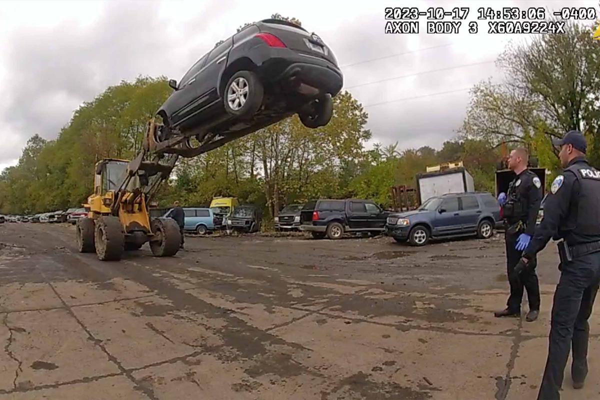 A forklift at Arlington Auto and Truck Wrecking raises a car with a suspected thief still inside 20 feet into the air until police arrive. (Courtesy of Akron Police Department)
