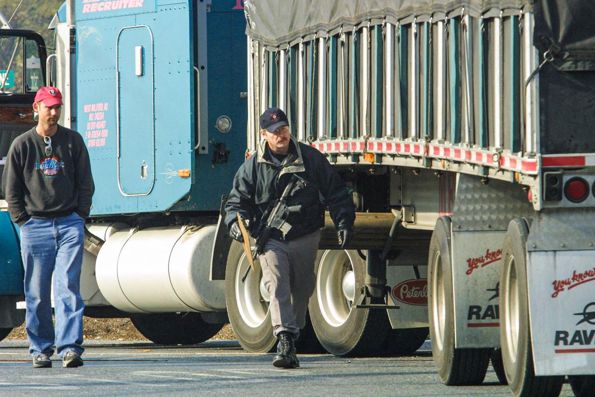 A Pennsylvania State Trooper (R) inspects a tractor-trailer before allowing the driver (L) to enter the Three Mile Island nuclear generating station site, in Middletown, Pa., on Nov. 1, 2001. (TOM MIHALEK/AFP via Getty Images)