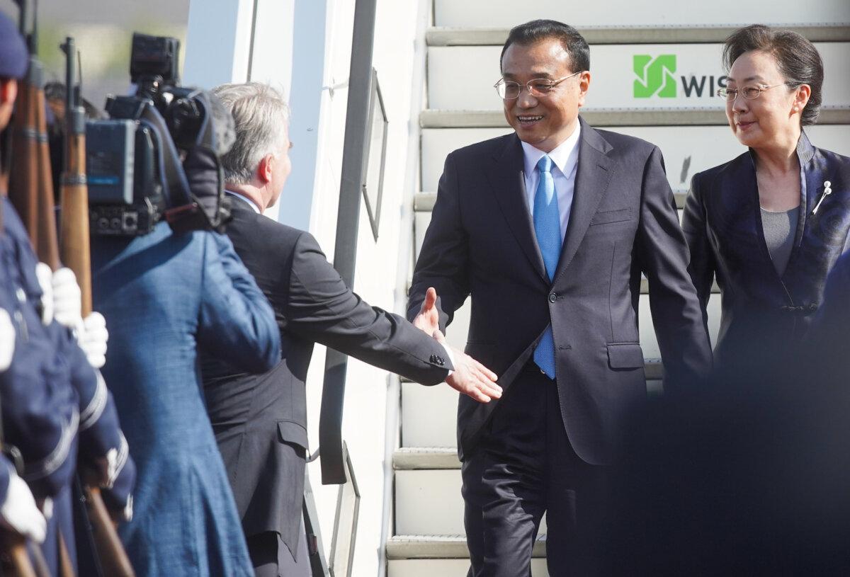 Chinese Premier Li Keqiang and his wife, Cheng Hong, are welcomed as they disembark from the airplane upon arrival in Berlin on July 8, 2018. (Jorg Carstensen/DPA/AFP via Getty Images)