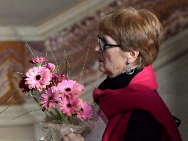Lee Carter holds a bouquet of flowers inside the Supreme Court of Canada on Feb. 6, 2015, ahead of the court’s decision on whether mentally competent but terminally ill patients have a right to a medically assisted death. (The Canadian Press/Sean Kilpatrick)