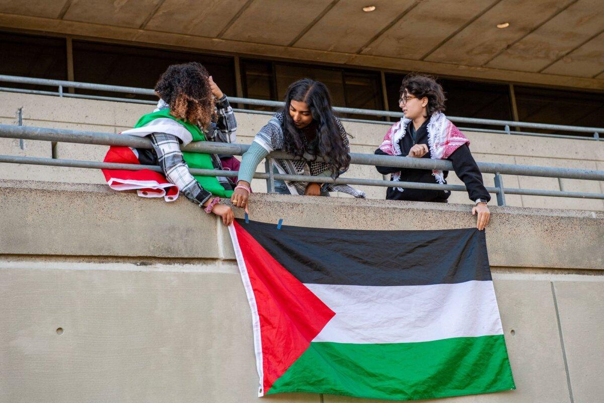 Pro-Palestinian students hang a Palestinian flag on the student centre wall at a rally to support Palestine at Massachusetts Institute of Technology in Cambridge, Mass., on Oct. 19, 2023. (Joseph Prezioso/AFP via Getty Images)