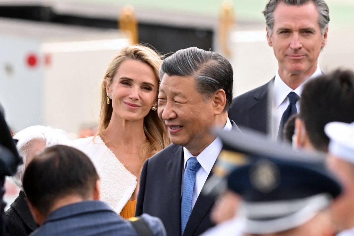 California Gov. Gavin Newsom (R) and his wife Jennifer Siebel Newsom (L) look on as Chinese leader Xi Jinping (C) arrives at San Francisco International airport, to attend the Asia-Pacific Economic Cooperation leaders' week in San Francisco, Calif., on Nov. 14, 2023. (Frederic J. Brown/AFP via Getty Images)