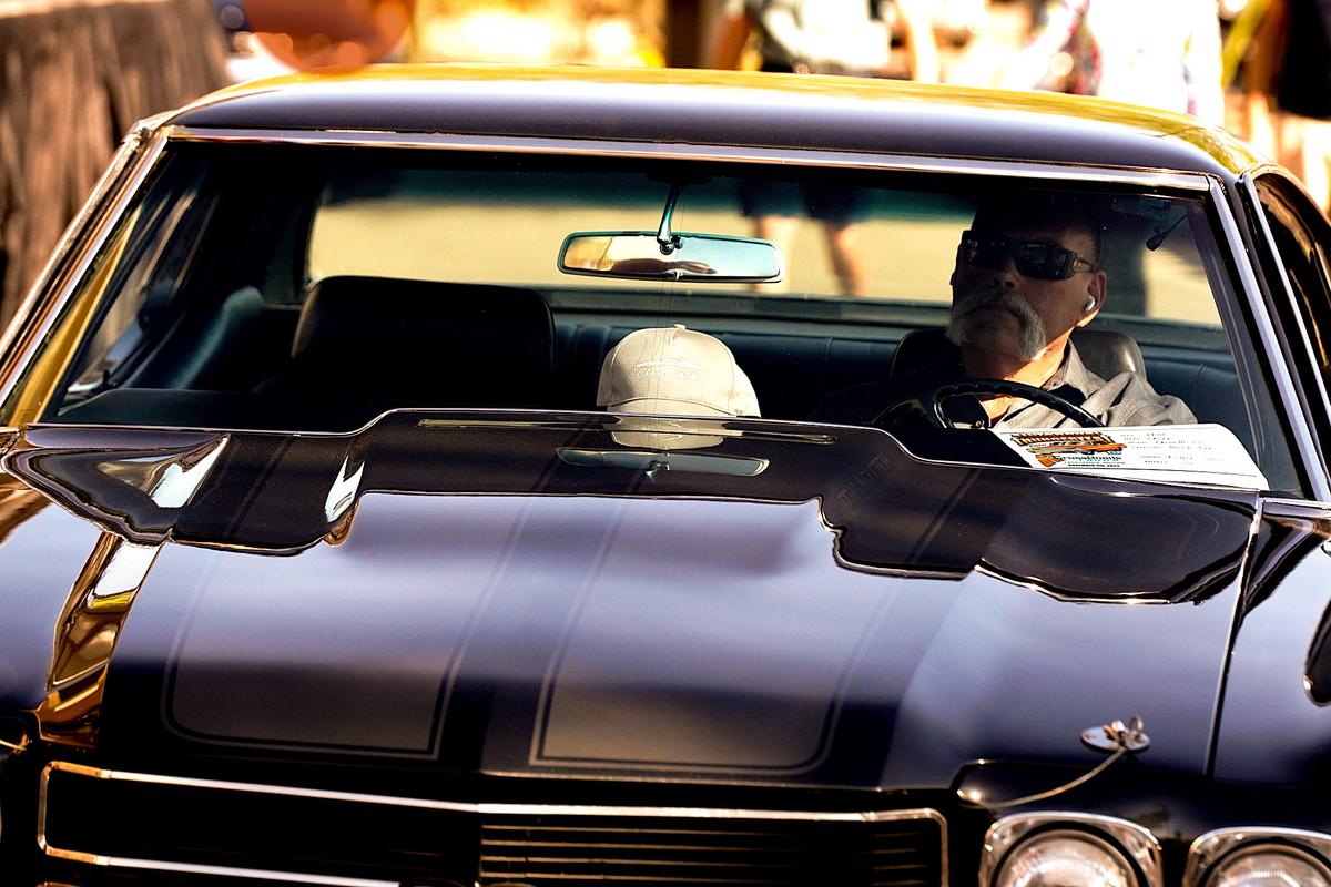 A classic car show contestant in Casa Grande, Ariz., on Nov. 4, 2023 driving his muscle car after the show. (Allan Stein/The Epoch Times)