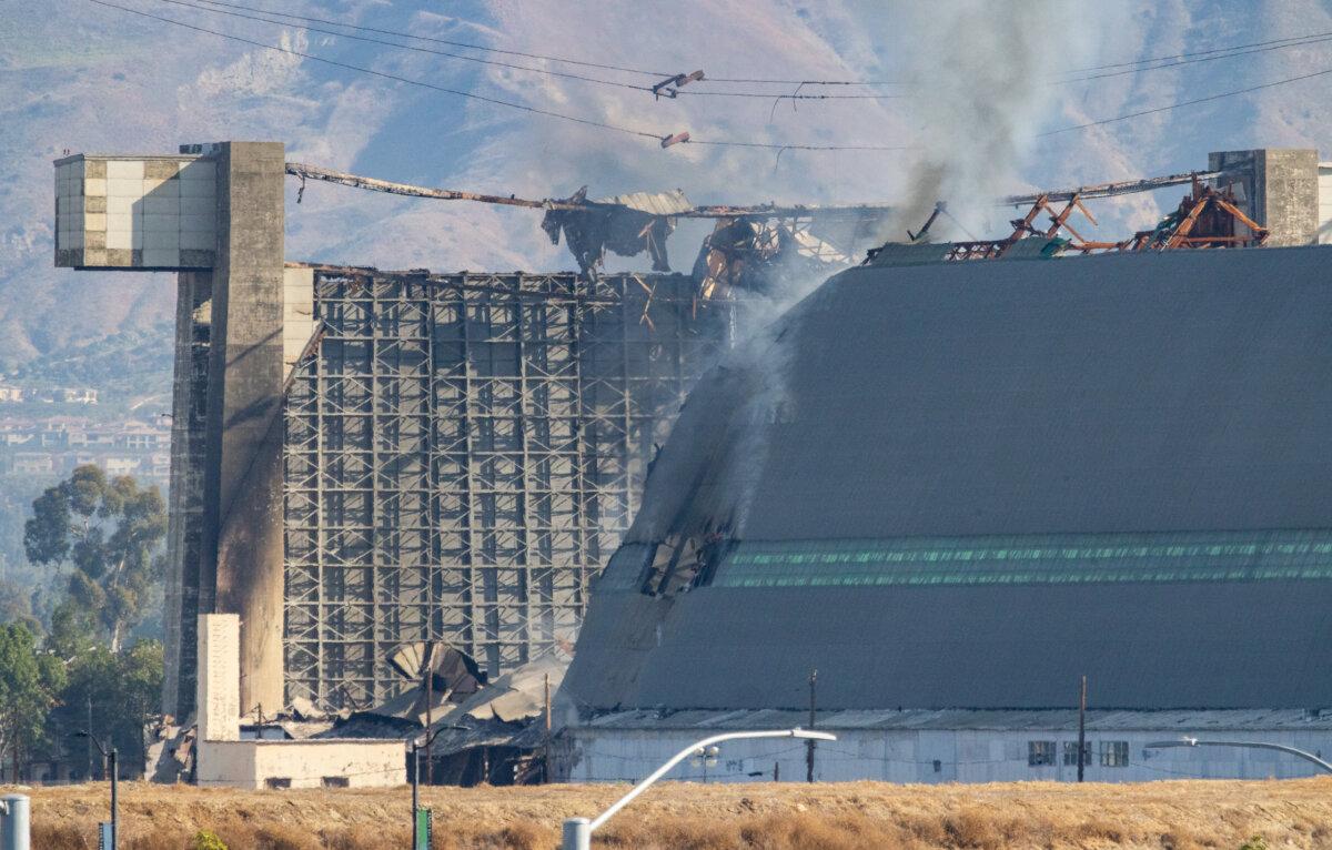 A fire continues to burn a historic blimp hangar in Tustin, Calif., on Nov. 14, 2023. (John Fredricks/The Epoch Times)