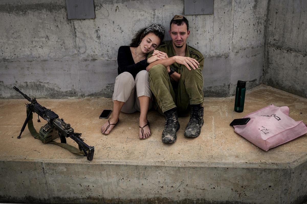 A newlywed Israeli soldier is visited by his wife as he takes a break near the border with Gaza in southern Israel on Nov. 14, 2023. (Christopher Furlong/Getty Images)