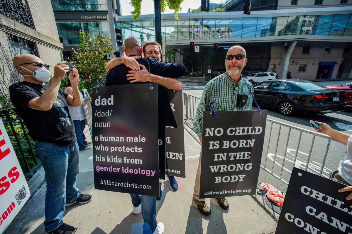 Activist Chris Elston, known as Billboard Chris (2nd L), embraces a supporter as he demonstrates against “gender-affirming” treatments and surgeries on minors outside of Boston Children’s Hospital in Massachusetts on Sept. 18, 2022. (Joseph Prezioso/AFP via Getty Images)